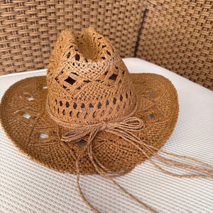 Detalhe do chapéu cowboy de palha com trama vazada e aba larga