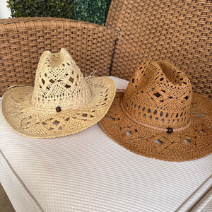 Chapéu de palha cowboy estilo western em tom natural sobre superfície de palha