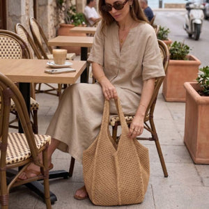 Mulher usando Bolsa de Crochê Venezia Cáqui em ambiente de resort