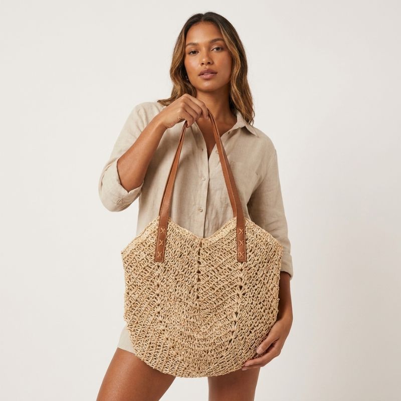 Bolsa de praia de palha bege vazada em look de verão