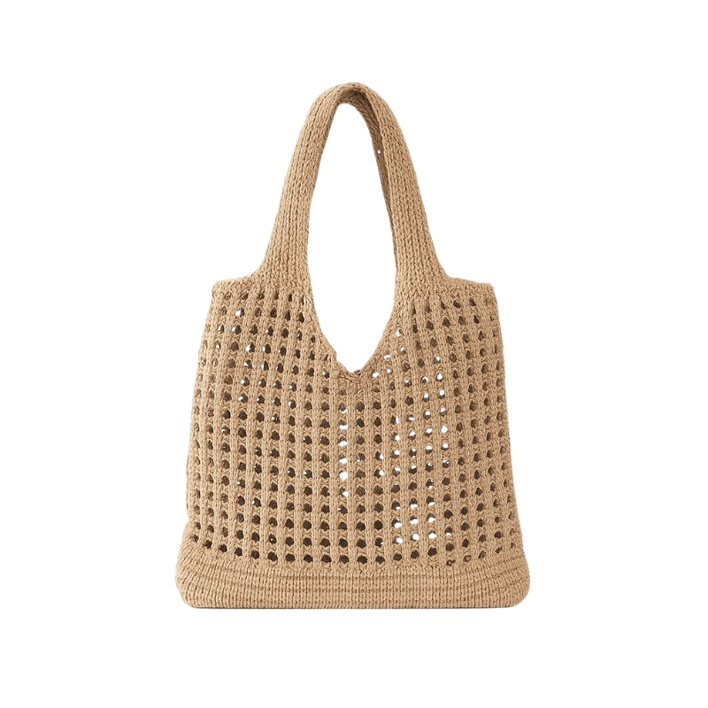 Bolsa de praia em crochê bege com trama vazada e alças longas em fundo branco