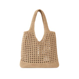 Bolsa de praia em crochê bege com trama vazada e alças longas em fundo branco