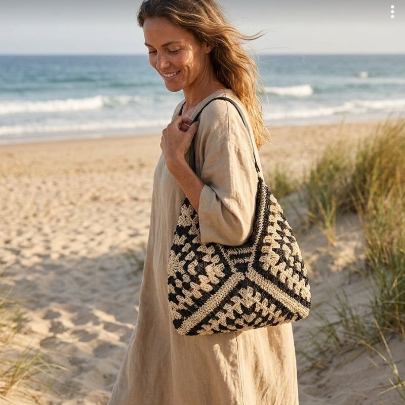 Mulher usando Bolsa de Crochê Clara em passeio próximo à praia