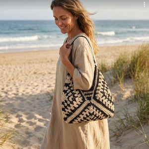 Mulher usando Bolsa de Crochê Clara em passeio próximo à praia