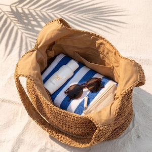 Interior da Bolsa de Palha Rattan Cáqui com itens de praia organizados