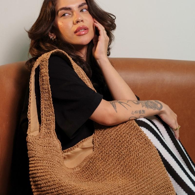 Bolsa de palha rattan cáqui vista lateral mostrando estrutura leve e sofisticada
